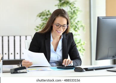 Happy businesswoman wearing suit working using a calculator in a desk at office