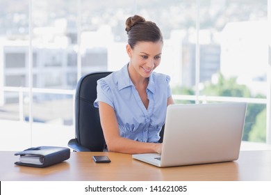 Happy businesswoman working on her laptop in the office - Powered by Shutterstock