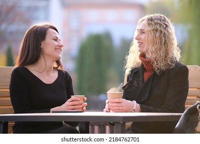 Happy Businesswomen Talking Together During Coffee Break Meeting At Urban Street Cafe. Friendship Between Business Partners Concept