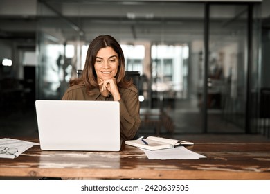 Happy busy mature business woman entrepreneur in office using laptop at work, smiling professional middle aged female company executive manager working looking at computer at workplace.