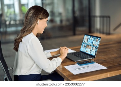 Happy busy mature middle aged female team leader manager executive having hybrid office business group meeting, remote workers discussing work plans by video digital conference call looking on laptop. - Powered by Shutterstock