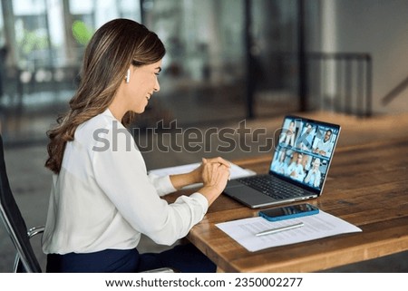 Happy busy mature middle aged female team leader manager executive having hybrid office business group meeting, remote workers discussing work plans by video digital conference call looking on laptop.