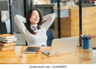 Happy Calm Asian Girl Student Relaxing Holding Hands Behind Finished Study Work Breathing Fresh Air Sit At Home Office Desk Feel Stress Relief Stretching Doing Exercise Dreaming Enjoy Peace Of Mind