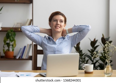 Happy calm business woman employee take break at work relax sit in ergonomic chair at office desk rest from computer hold hands behind her head feel no stress free relief at workplace, peace of mind