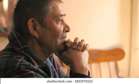 Happy calm relaxed senior man sitting at dinner table at home, looking ahead, thinking. Portrait, closeup