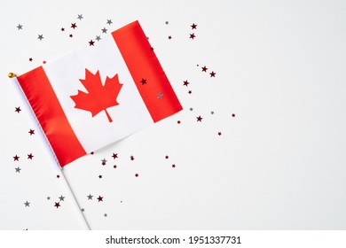 Happy Canada Day greeting card poster with Canadian flag and confetti on white background. Flat lay, top view. - Powered by Shutterstock