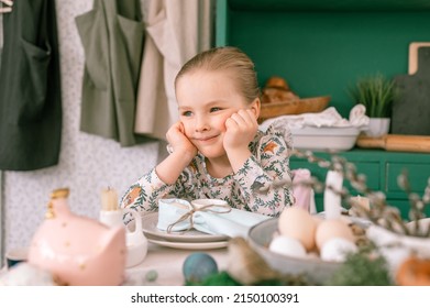 Happy Candid Little Kid Four Year Old Girl Bored With Hands Fists In Face Ready And Waiting For Lunch Or Dinner Of Springtime Easter Holiday At Home Kitchen Decorated Festive Table With Easter Eggs