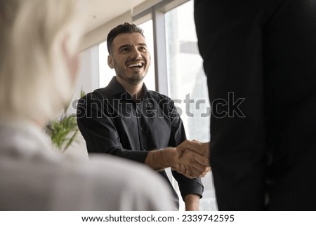 Happy candidate man getting job, shaking hands with employer after successful interview. Entrepreneur giving handshake to business partner, gesture of cooperation, friendship, partnership
