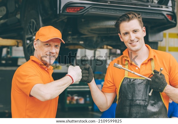 happy car mechanic service team enjoy working\
together in garage