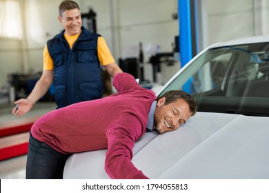 Happy Car Owner Feeling Relieved And Leaning On A Vehicle Hood In Auto Repair Shop. 