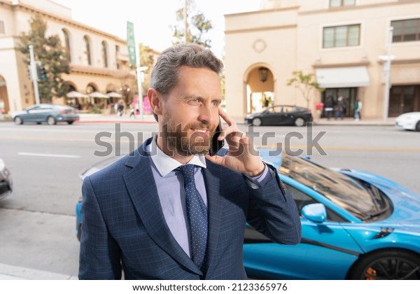 happy car rent\
dealer speaking on phone\
outdoor