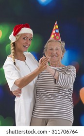 Happy Care Giver Dancing With Senior Woman At Retirement House 