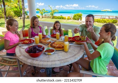 Happy Carefree Caucasian Family Wearing Casual Clothing Eating Dinner At Exotic Outdoor Beach Restaurant And Enjoying Vacation Bahamas