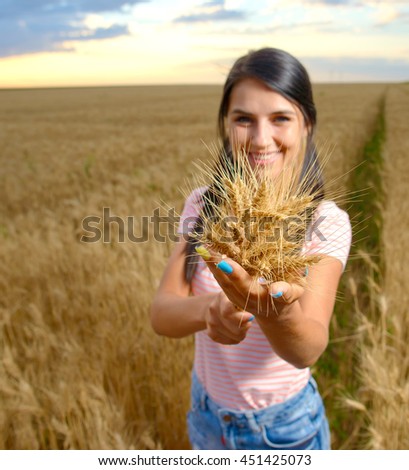 happy carefree summer girl in sunflower field in summer with arms raised up