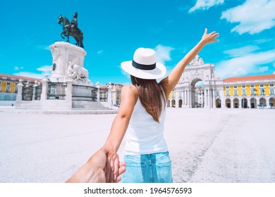 Happy carefree tourist woman in white hat leading her boyfriend and enjoying sunny summer holiday. Follow me. Couple on vacation. Traveling together. Commerce Square in Lisbon, Portugal. - Powered by Shutterstock