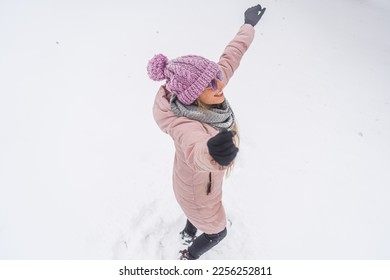 Happy carefree woman dancing with raised hands in the snow outdoor. High quality photo - Shutterstock ID 2256252811