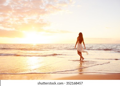 Fröhliche und sorgenfreie Frauen, die den schönen Sonnenuntergang am Strand genießen