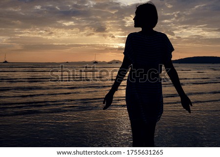 Happy Carefree Woman Enjoying Beautiful Sunset on the Beach. famous Ao Nang beach in Krabi province, Thailand
