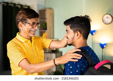 Happy caring grandfather blessing school going grandson with backback at home - concept of parental appreciation, achievement and elderly encouragement