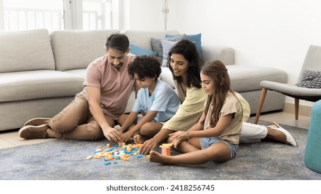 Happy caring parents and two sibling kids constructing towers from colorful toy blocks, playing learning game, training creative skills, enjoying family activity together, childhood, parenthood - Powered by Shutterstock