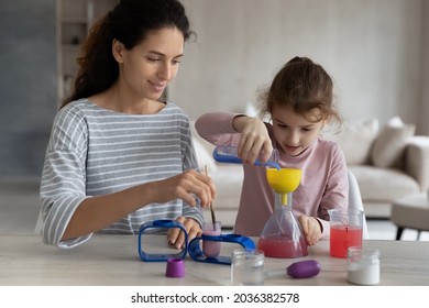 Happy caring young hispanic mother making chemical experiments or tests with smart cute kid daughter, improving knowledge, enjoying studying together in playful manner, homeschooling education concept