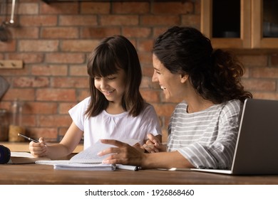 Happy Caring Young Latino Mom Do Home Work Learn Distant Use Computer With Small Biracial Daughter. Smiling Hispanic Mother Help Girl Child With Home Task Preparation. Online Education Concept.