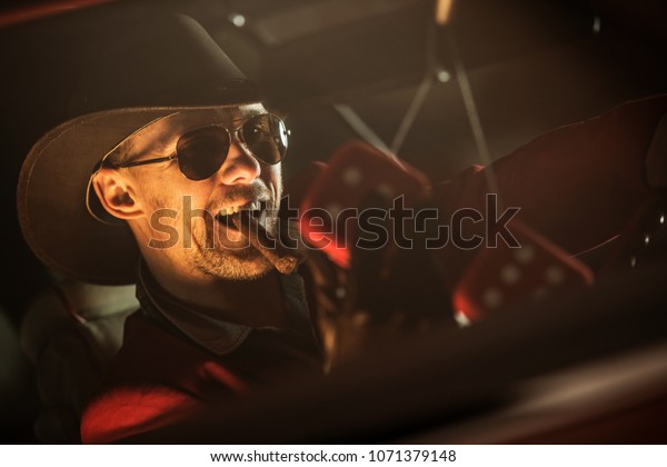 Happy Casino Jackpot Winner with\
Cigar Leaving Las Vegas in His Classic Car. Caucasian Men in His\
30s Wearing Western Style Clothes Included Cowboy\
Hat.