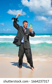 Happy Castaway Businessman Celebrating On A Tropical Beach Reading A Message In A Green Bottle