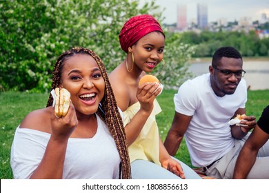 happy casual america african people having fun and eating burger outdoors lifestyle,students for a break summer evening cloudy weather in park