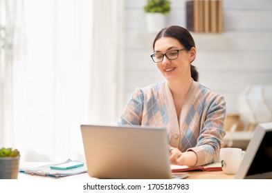 Happy casual beautiful woman working on a laptop at home.                                  