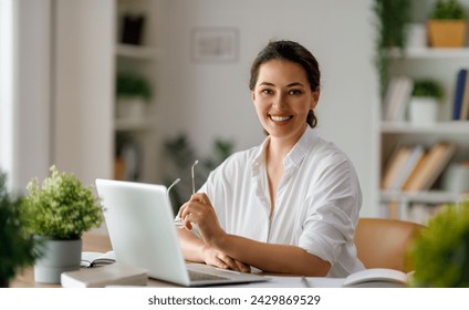 Happy casual beautiful woman working on a laptop in the office. - Powered by Shutterstock