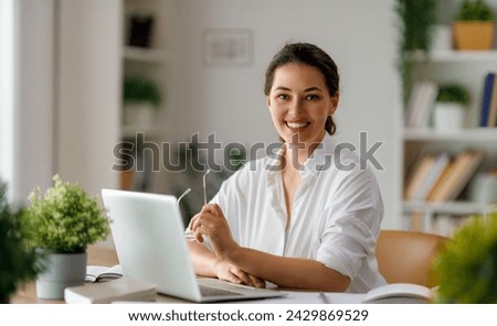 Happy casual beautiful woman working on a laptop in the office.