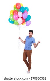 happy casual man holding a bunch of balloons is inviting to a party