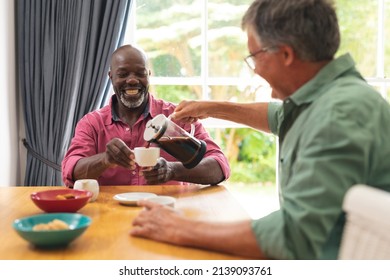 Happy Caucasian And African American Senior Male Friends Having Coffee At Home. Unaltered, Lifestyle, Social Gathering, Friendship, Togetherness And Leisure.