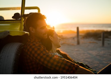 Happy caucasian couple leaning against beach buggy by the sea relaxing during sunset. beach break on summer holiday road trip. - Powered by Shutterstock