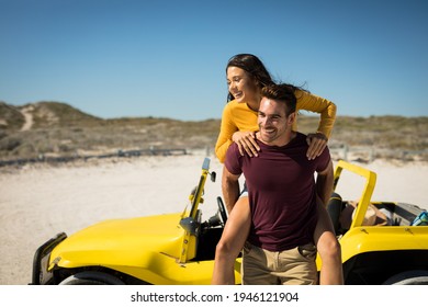 Happy caucasian couple next to beach buggy by the sea piggybacking. beach break on summer holiday road trip. - Powered by Shutterstock