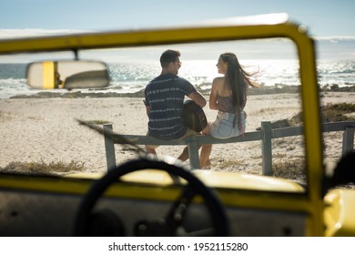 Happy caucasian couple next to beach buggy by the sea playing guitar. beach break on summer holiday road trip. - Powered by Shutterstock