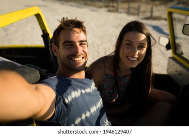 Happy caucasian couple sitting in beach buggy by the sea taking selfie. beach break on summer holiday road trip. - Powered by Shutterstock