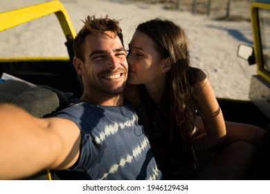 Happy caucasian couple sitting in beach buggy by the sea taking selfie. beach break on summer holiday road trip. - Powered by Shutterstock