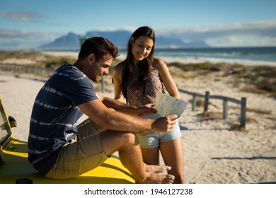 Happy caucasian couple sitting on beach buggy by the sea checking map. beach break on summer holiday road trip. - Powered by Shutterstock