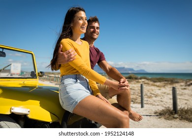 Happy caucasian couple sitting on beach buggy by the sea holding hands. beach break on summer holiday road trip. - Powered by Shutterstock