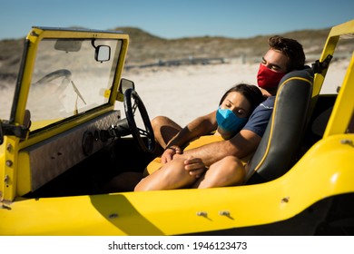 Happy caucasian couple wearing face masks sitting in beach buggy relaxing. beach stop off on summer holiday road trip during coronavirus covid 19 pandemic. - Powered by Shutterstock