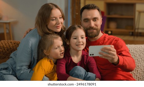 Happy Caucasian family talking mobile phone video call webcam cheerful smiling mother father little girls children siblings kids waving hello greet at home parents daughters online blog selfie photo - Powered by Shutterstock