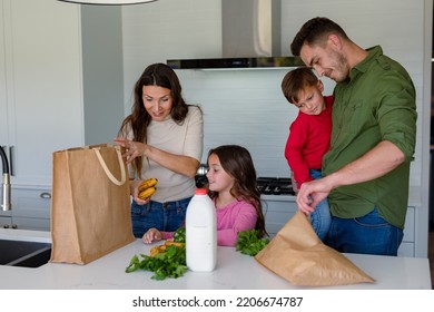 Happy Caucasian Family Unpacking Groceries Together In Kitchen. Family Time, Having Fun Together At Home.