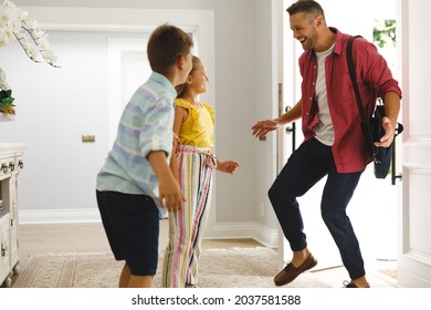 Happy Caucasian Father Returning Home With Daughter And Son Smiling And Greeting Him At Front Door. Hospitality And Welcoming Guests At Home.