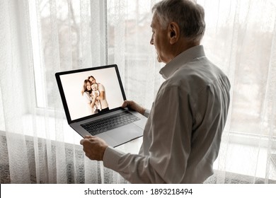 Happy Caucasian Grandfather Hold A Laptop, Talking With Family By Internet. Mature Handsome Male Having A Video Call With Grandchildren. Older Man Use Zoom, Technology Concept. High Quality Photo