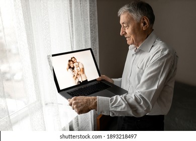 Happy Caucasian Grandfather Hold A Laptop, Talking With Family By Internet. Mature Handsome Male Having A Video Call With Grandchildren. Older Man Use Zoom, Technology Concept. High Quality Photo