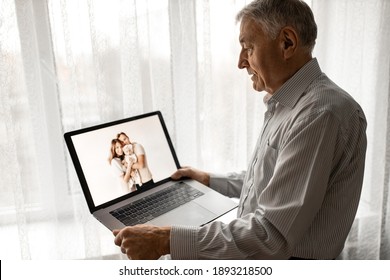 Happy Caucasian Grandfather Hold A Laptop, Talking With Family By Internet. Mature Handsome Male Having A Video Call With Grandchildren. Older Man Use Zoom, Technology Concept. High Quality Photo