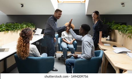 Happy Caucasian Male Leader Give High Five Motivate African Employee At Diverse Group Office Meeting Express Friendship Business Agreement Good Teamwork Result Share Company Success At Team Briefing.