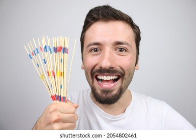 Happy Caucasian Man Showing Mikado Pick Up Sticks